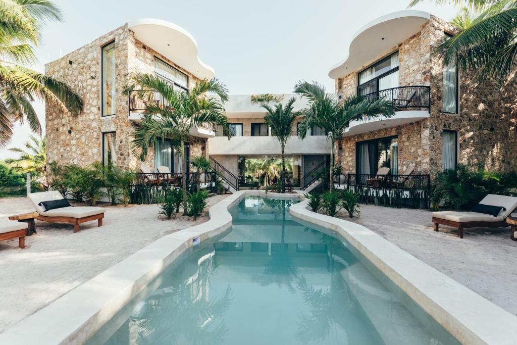 una piscina di fronte a un edificio con un resort di Cucu Hotel El Cuyo a El Cuyo