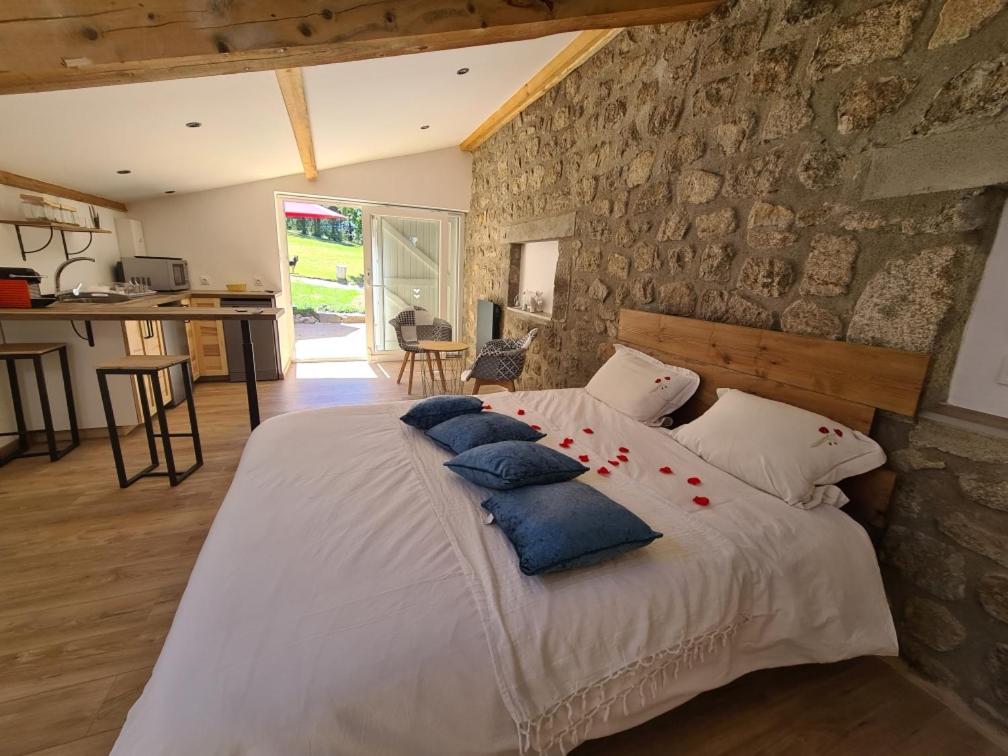 1 dormitorio con 1 cama blanca grande con almohadas azules en Room lover Les Chaizes, en Saint-Romain-Lachalm