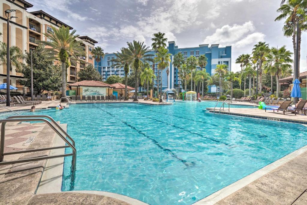 a large swimming pool with palm trees and buildings at Floridays Resort Condo Less Than 4 Mi to Walt Disney! in Orlando