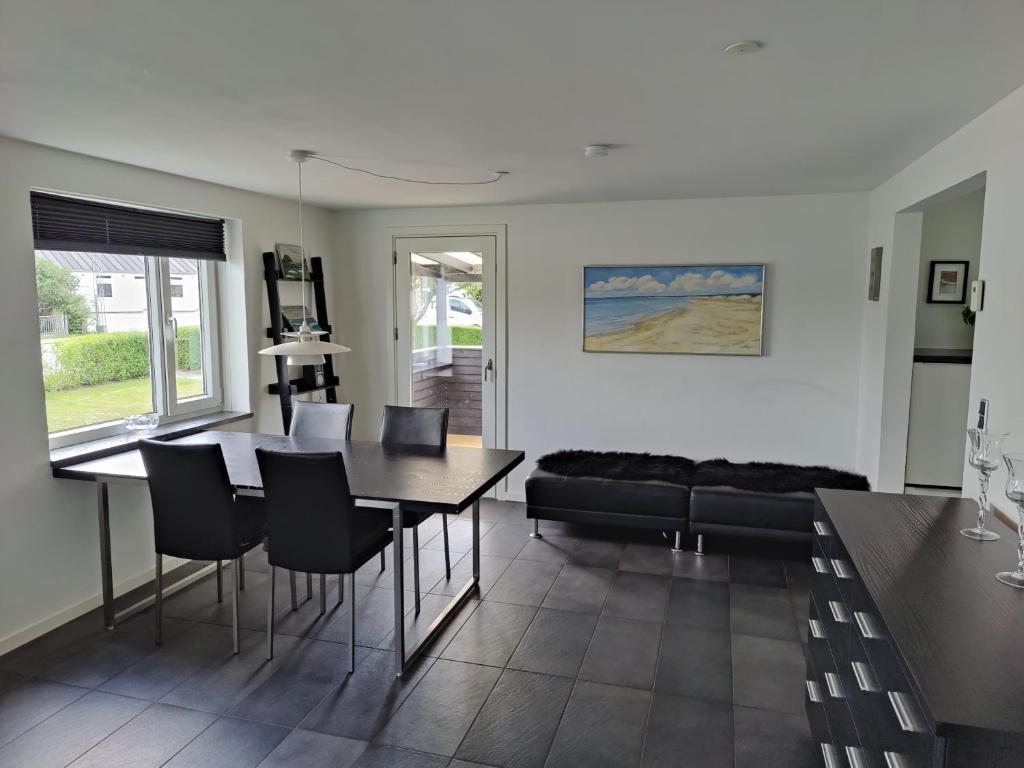 een woonkamer met een tafel en stoelen en een bank bij Bjergby Guesthouse in Hjørring