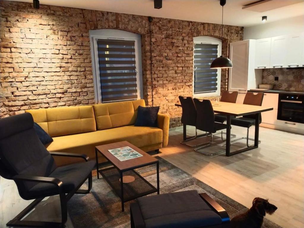 a living room with a couch and a table at Apartament Loftowy Głuszyca in Głuszyca
