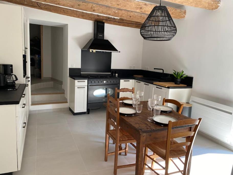 a kitchen with a wooden table with chairs and a stove at Le Lodge du Lac in Talloires