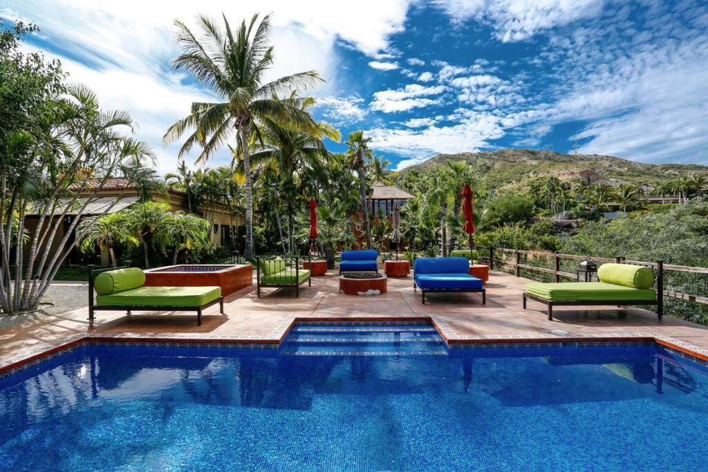 una piscina con tumbonas y una piscina en Villa Vida Cabo - Authentic Spacious Ocean View Near Beach & Town, en San José del Cabo