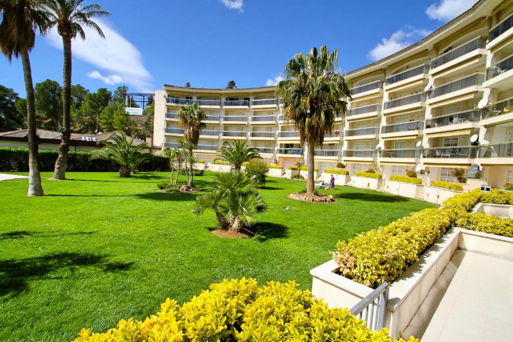 ミアミ・プラトーヤにあるARENDA Apartamento Flamencos 114のヤシの木と庭のあるホテルの外観