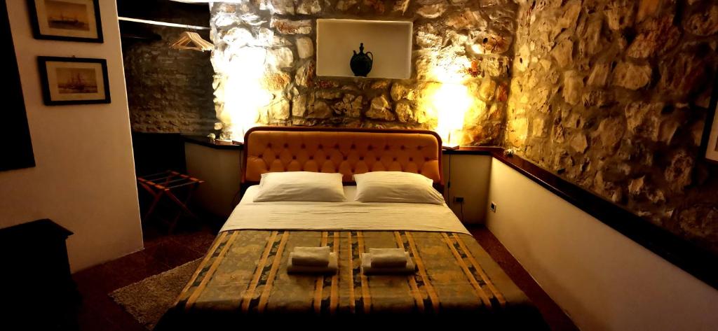 a bed in a room with a stone wall at Bella Vista apartments with hot pool and jacuzzi in Trogir