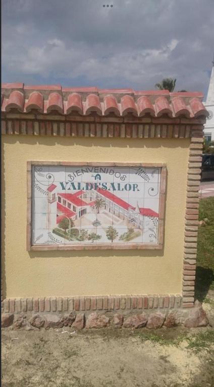 a sign on the side of a yellow building at Alojamiento El Miajon de los Castúos in Valdesalor