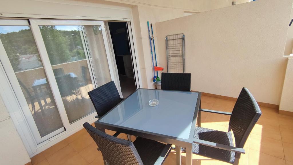 a table and chairs in a room with a large window at Apartamentos Cala Azul La Móra in Tarragona
