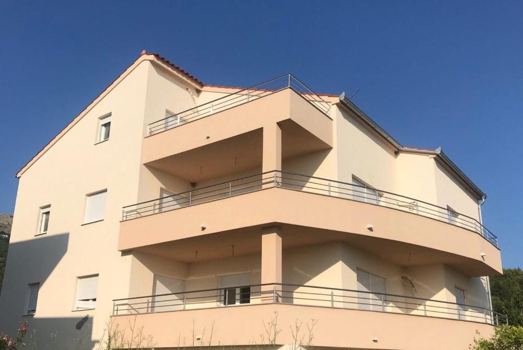un edificio con balcones en un lateral en Villa Ana perfect for families with kids and groups,House with heated Pool en Podstrana