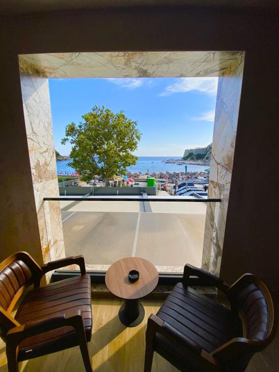 Habitación con ventana grande con mesa y sillas. en Marinus Hotel en Ulcinj