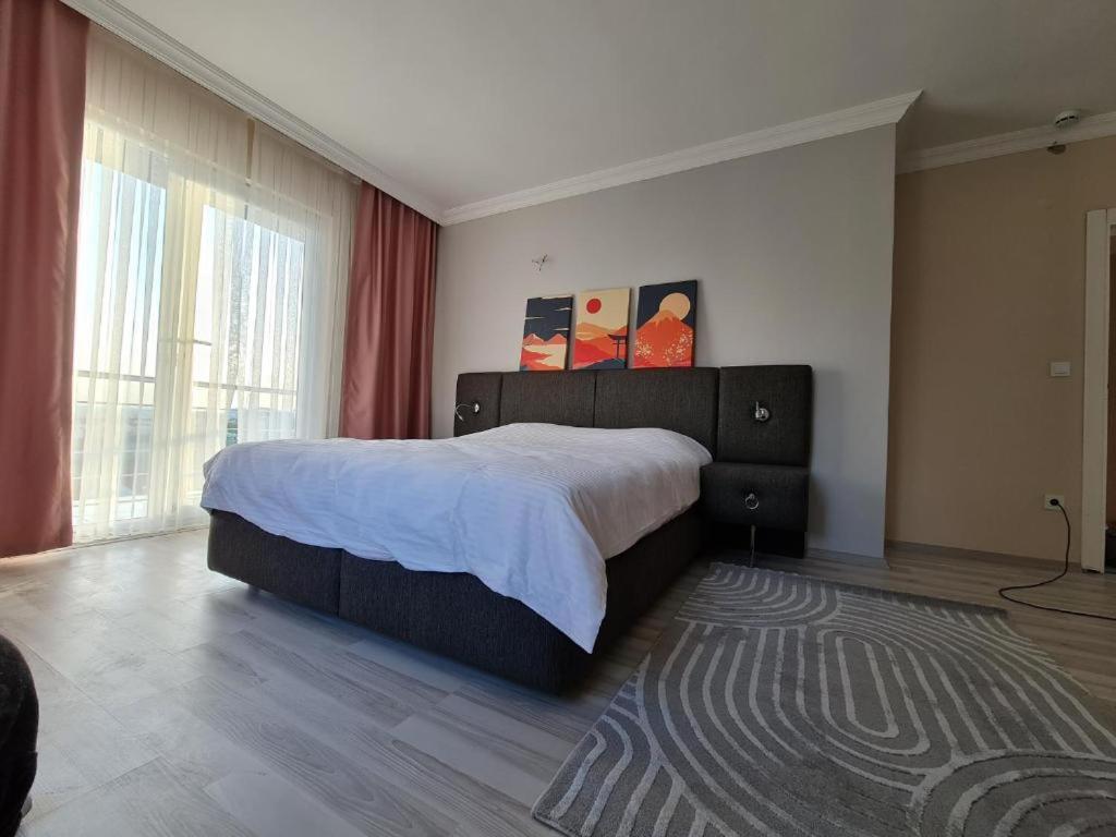 1 dormitorio con cama grande y ventana grande en Private Villa Room Near Airport, en Arnavutköy