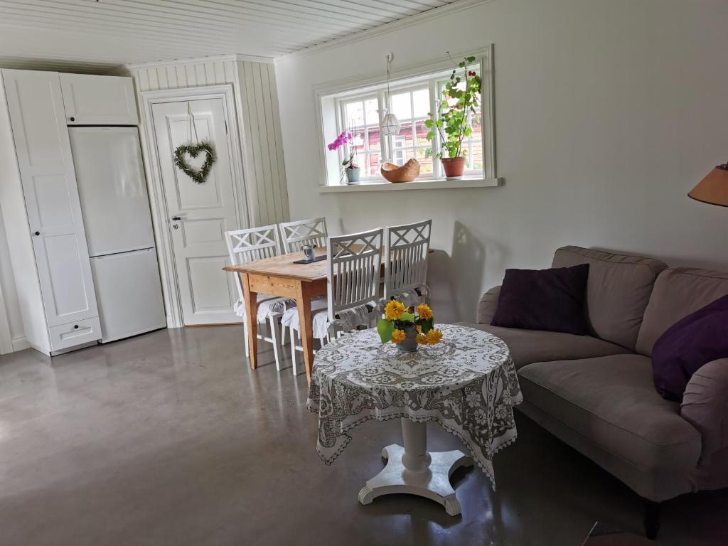 un soggiorno con tavolo e divano di Idyllisk nybyggd stuga på Sollerön. a Sollerön