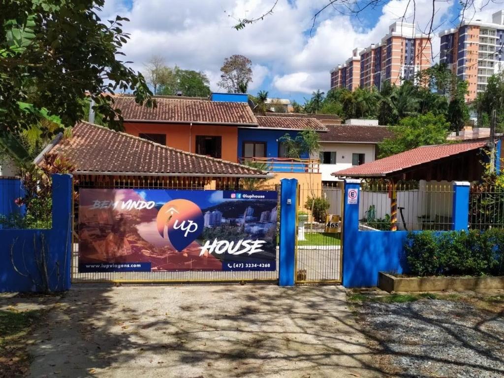 ein Tor zu einem Haus mit einem Schild darauf in der Unterkunft iUP HOUSE Hostel in Blumenau