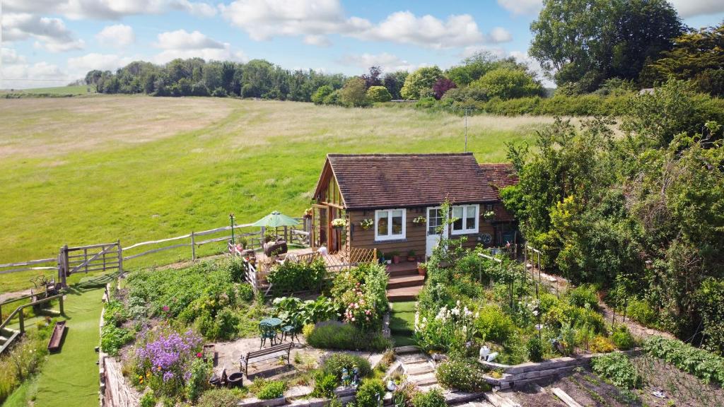 una pequeña casa en un campo con jardín en Observatory at South Downs Stay, en Houghton