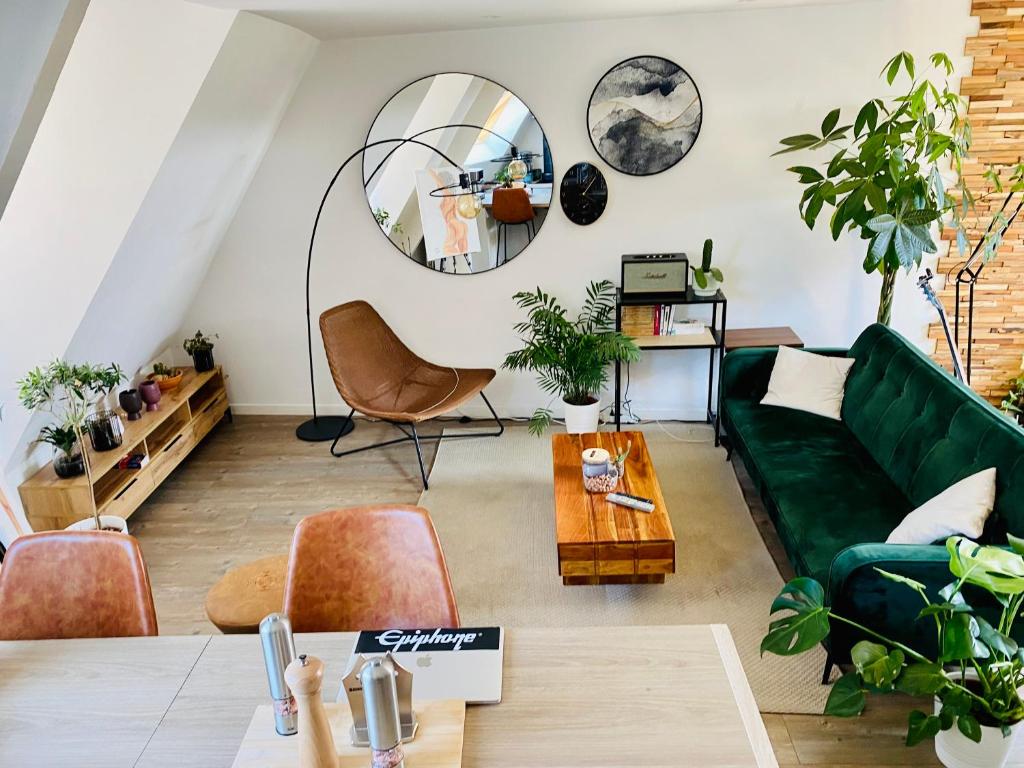 sala de estar con sofá verde y espejo en Duplex-centre ville, en Caen