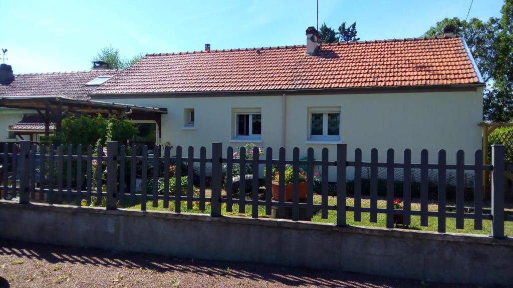 une clôture noire devant une maison blanche dans l'établissement La petite maison de Paule, à Amilly