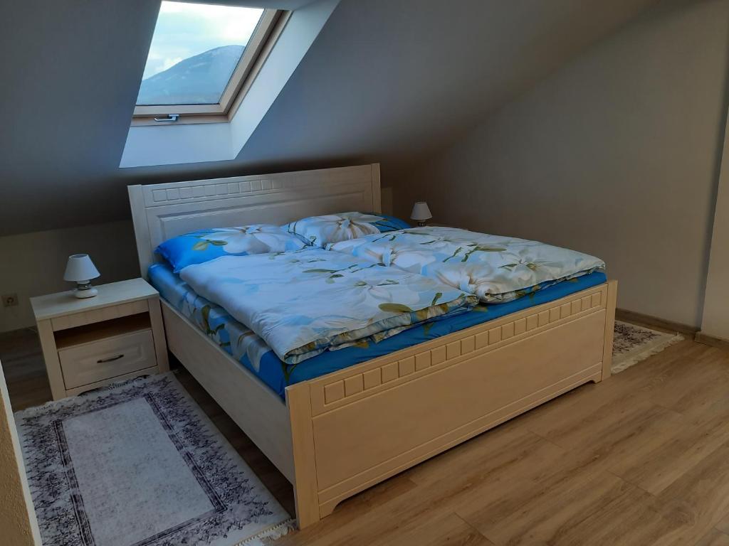 1 dormitorio con 1 cama con edredón azul y ventana en Privat Magnolia, en Mošovce