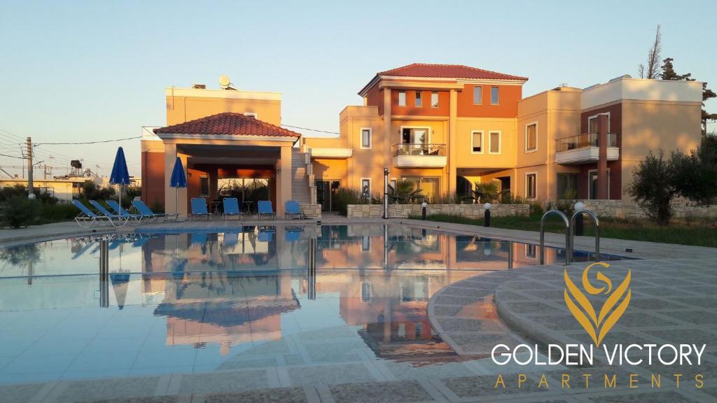 a swimming pool in front of some buildings at Golden Victory in Agia Marina Nea Kydonias