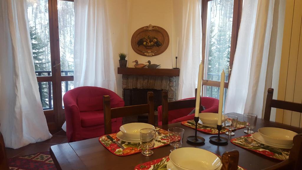 a dining room with a table and chairs and a fireplace at coeur de neige in Claviere
