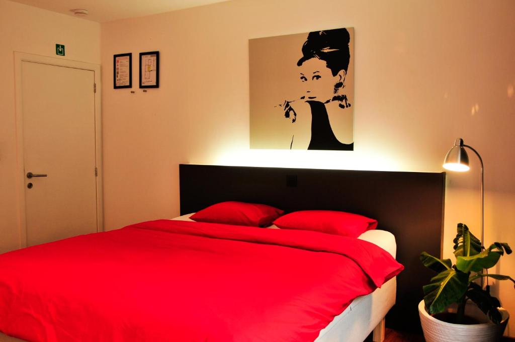 
a bedroom with a bed and a lamp at Logies Zen aan Zee in Ostend
