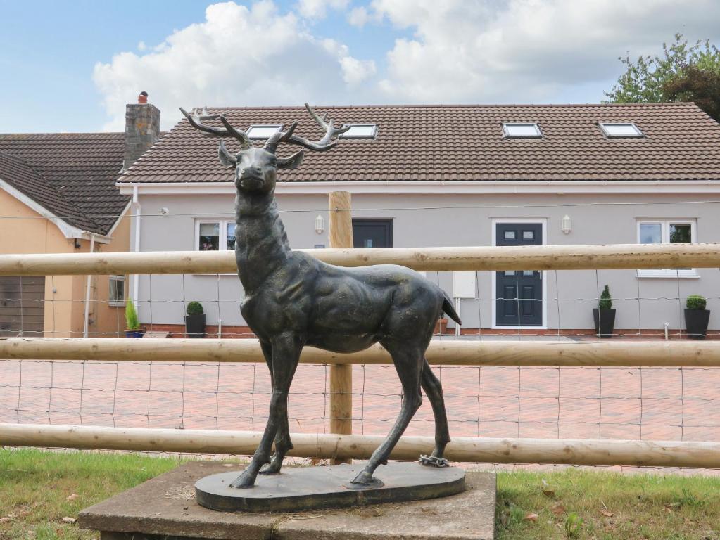 une statue de cerf devant une clôture dans l'établissement Sawtons Cottage 2, à Dawlish