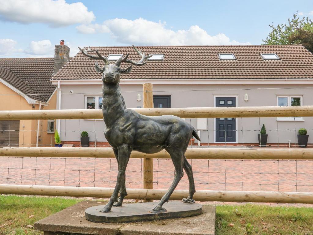 a statue of a deer in front of a fence at Sawtons Cottage 1 in Dawlish