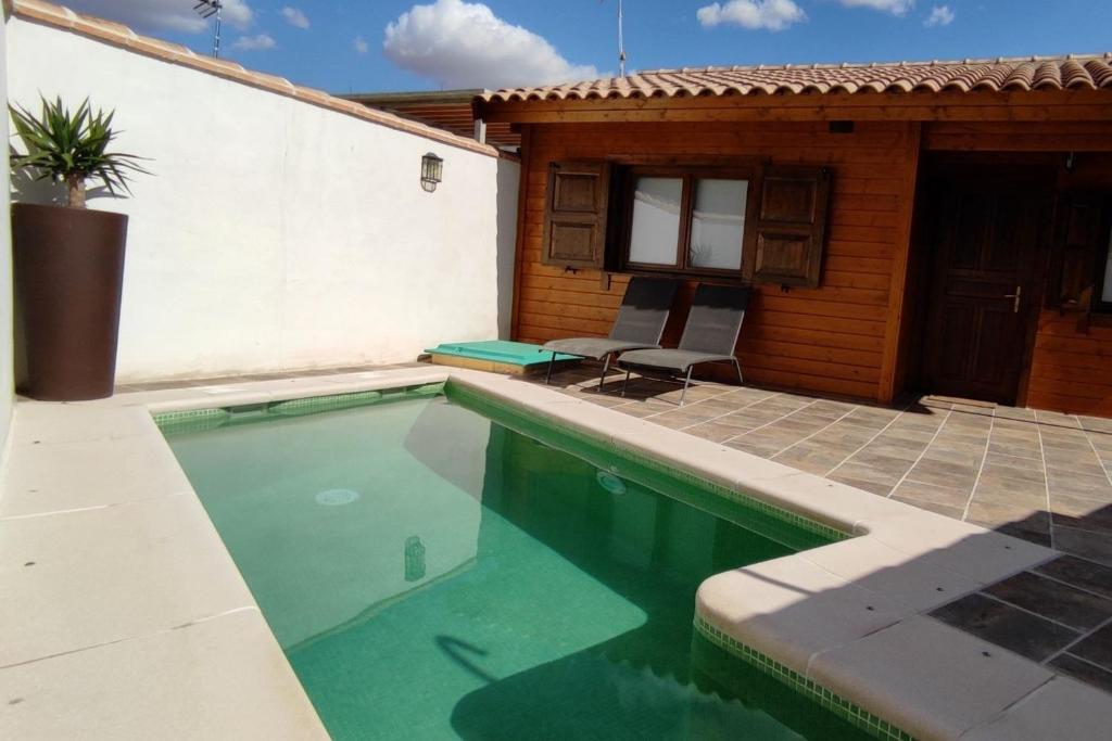 una piscina frente a una casa en La Dehesilla de Toledo Escapada Romántica Jacuzzi Sillón Tántrico en Cobisa