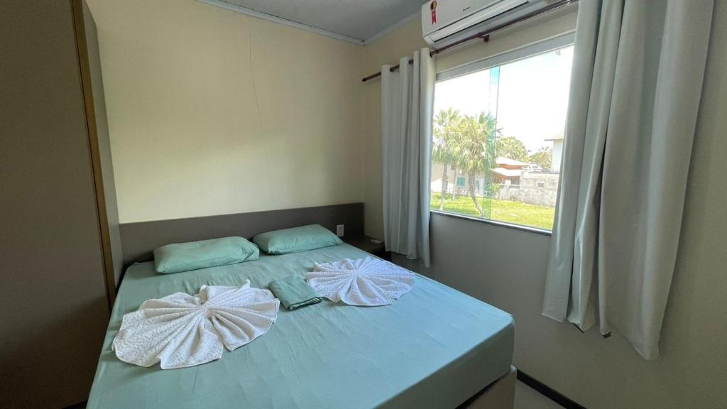 a bedroom with a bed with two pillows on it at Lencóis Ville Residence in Barreirinhas