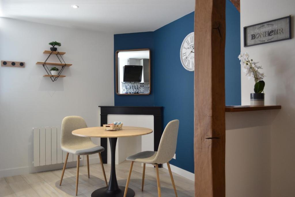 a table and chairs in a room with a blue wall at L&#39;essentiel de Chartres in Chartres