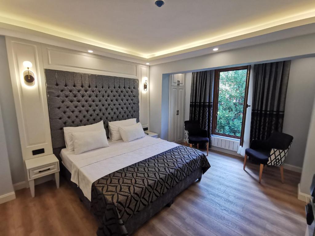 um quarto com uma cama grande e uma janela grande em Luxx Garden Hotel em Istambul