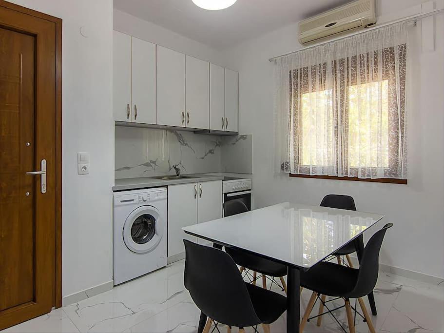 a kitchen with a table and chairs and a washing machine at Hersonissos Modern One Bedroom Apartment Beachside in Hersonissos