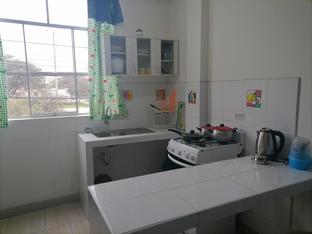 a kitchen with a stove and a white counter top at Departamento - Los Mitos del Parque M2 in Chiclayo