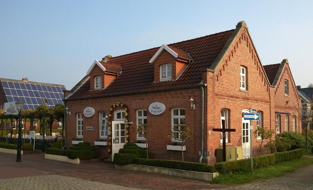 um edifício de tijolos vermelhos com um relógio em Stoevchen Café Hotel em Papenburg