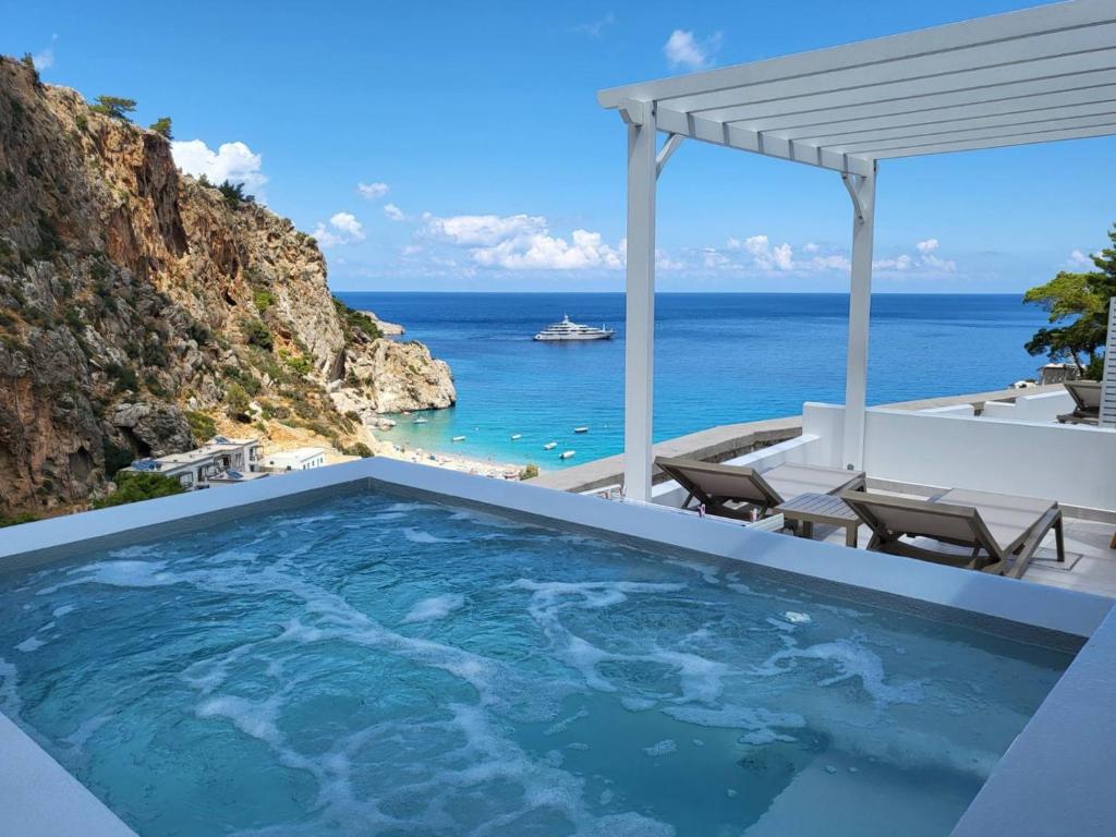uma piscina com vista para o oceano em Agnantema luxury suites em Cárpatos