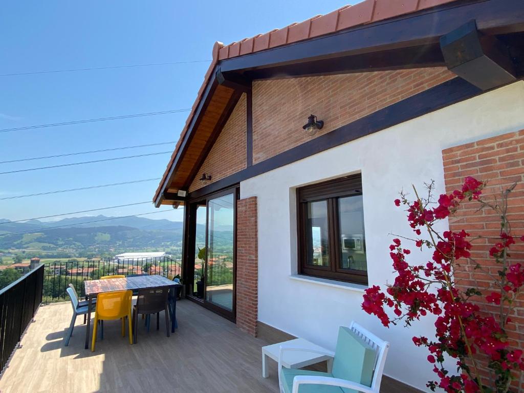 a house with a balcony with a table and chairs at Casa Los Rinocerontes in Penagos