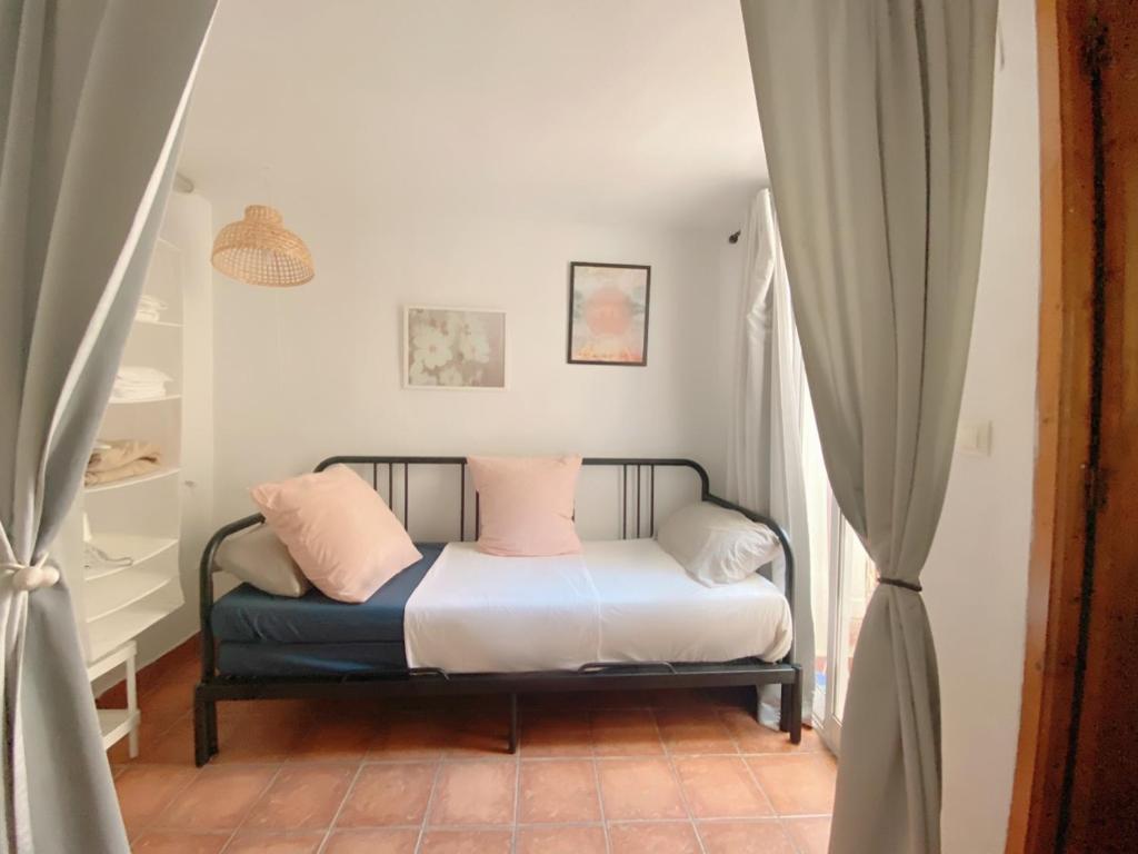 a bedroom with a bed with pink and white pillows at Preciosa villa en el corazón de Gandia in Gandía