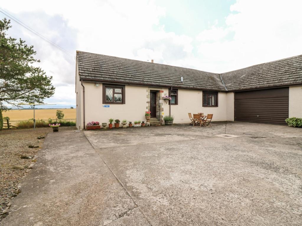 a detached house with a driveway and a garage at Courtyard Cottage in Duns