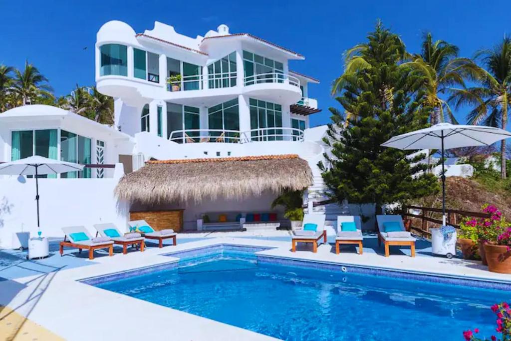 een villa met een zwembad en een huis bij Hermosa Villa con alberca infinita Playa Zipolite in Puerto Ángel