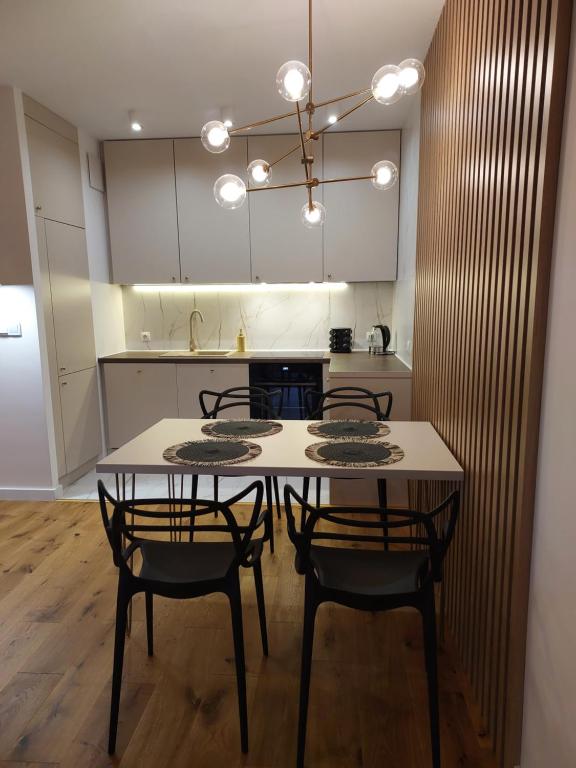 comedor con mesa y sillas en la cocina en M2 Bemowo apartament, en Warszawa
