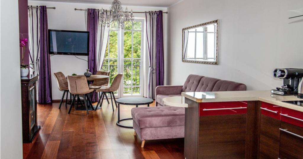 uma sala de estar com um sofá e uma mesa em Zachód Słońca Apartments em Mielno