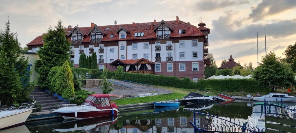 duży budynek z łodziami zacumowanych w zbiorniku wodnym w obiekcie Apartamenty Przy Porcie 54m2 oraz 31m2 z Tarasem w Węgorzewie