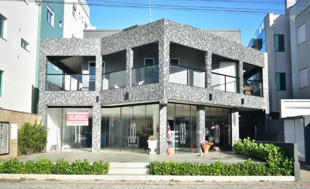 ein Gebäude mit Glasfenstern in einer Stadt in der Unterkunft Residencial Melfi 3 Ap. 7 Fundos in Bombinhas