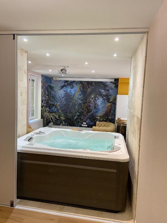 a jacuzzi tub in a bathroom with a painting at Loft "Eden" jaccuzi prestations haut de gamme 92m2-2 chbres in Chamalières