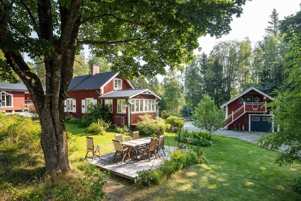 een achtertuin met een tafel en stoelen en een huis bij Höga Backe Gästhus in Asphyttan