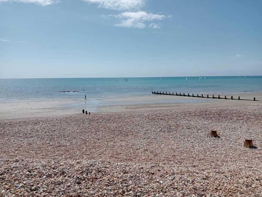 uma praia de areia com um cais na água em Seaside Annexe em Felpham