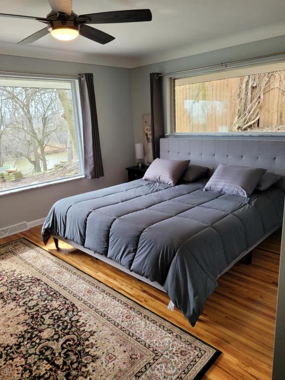 a large bed in a bedroom with a large window at dock, game room, bar and private river view patio in Toledo
