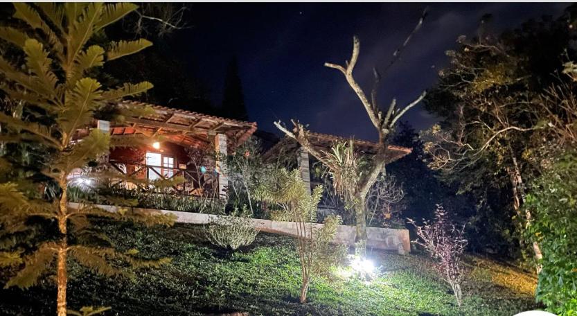 une maison la nuit avec des lumières devant elle dans l'établissement Chalé romântico , rústico e vista de tirar o fôlego, à Guaramiranga