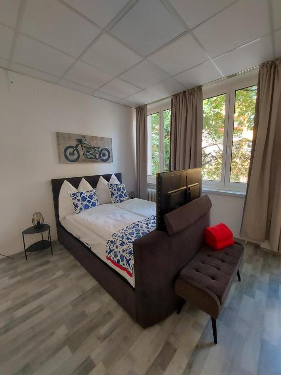 Schlafzimmer mit einem Bett, einem Stuhl und Fenstern in der Unterkunft Apartman Favorita in Wien
