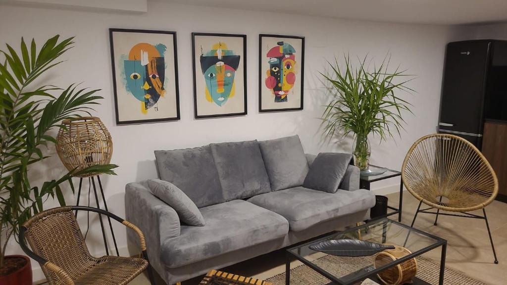 uma sala de estar com um sofá e quatro fotografias na parede em A Casina em Combarro