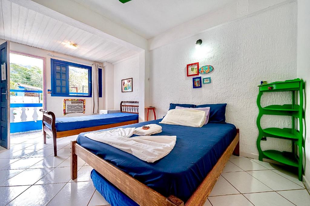 um quarto com 2 camas e uma escada verde em Pousada Água Marinha-Familias & Pets em Angra dos Reis