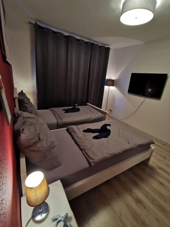 2 Einzelbetten in einem kleinen Zimmer mit einem TV in der Unterkunft Liebevoll eingerichtete Ferienwohnung - Zentrale Lage - Netflix & Paytv in Wilhelmshaven